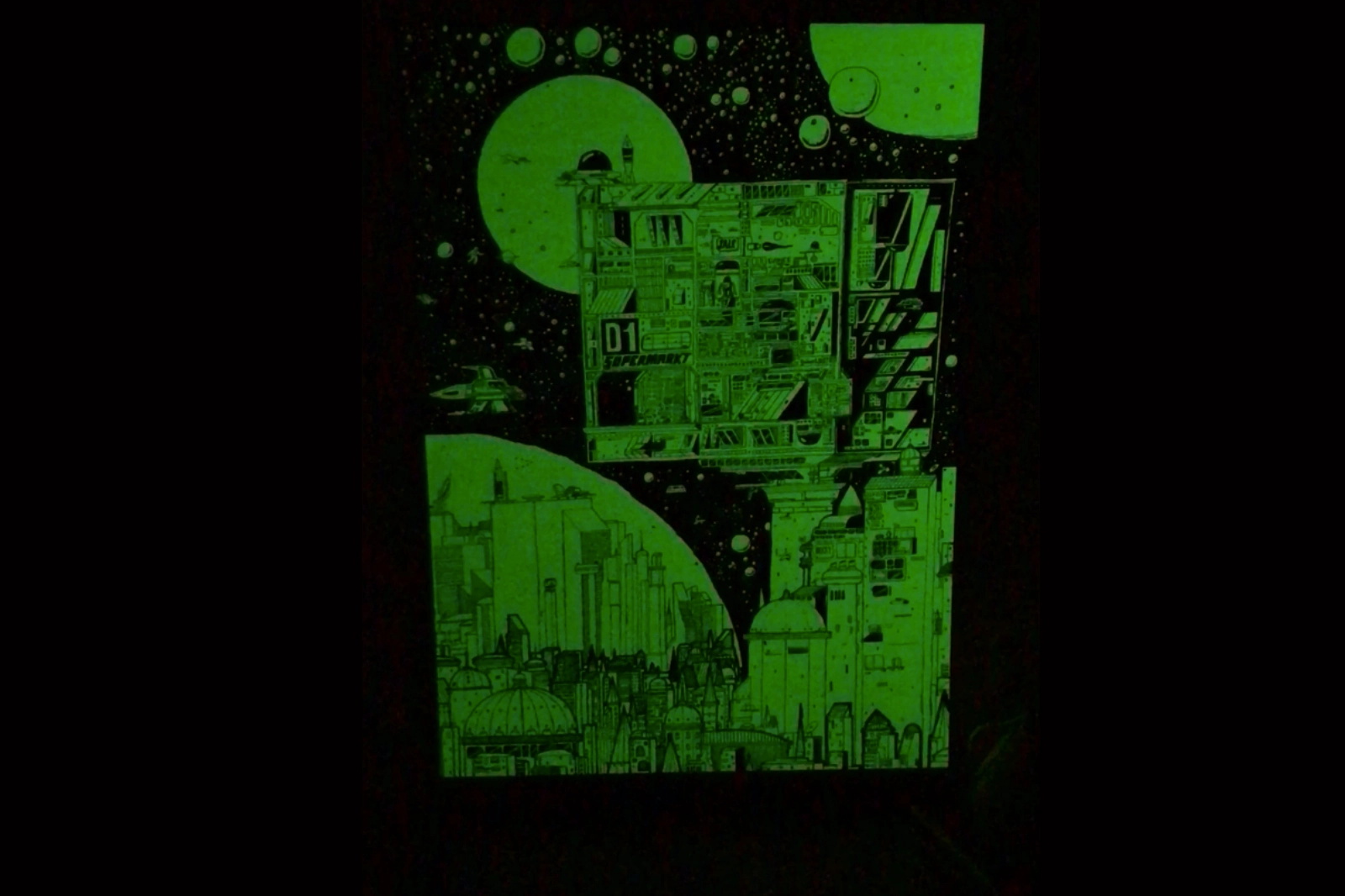 Das „Krom City“-Poster leuchtet im Dunkeln; die phosphoreszierenden Elemente wie Raketen, Linien und futuristische Formen werden sichtbar.