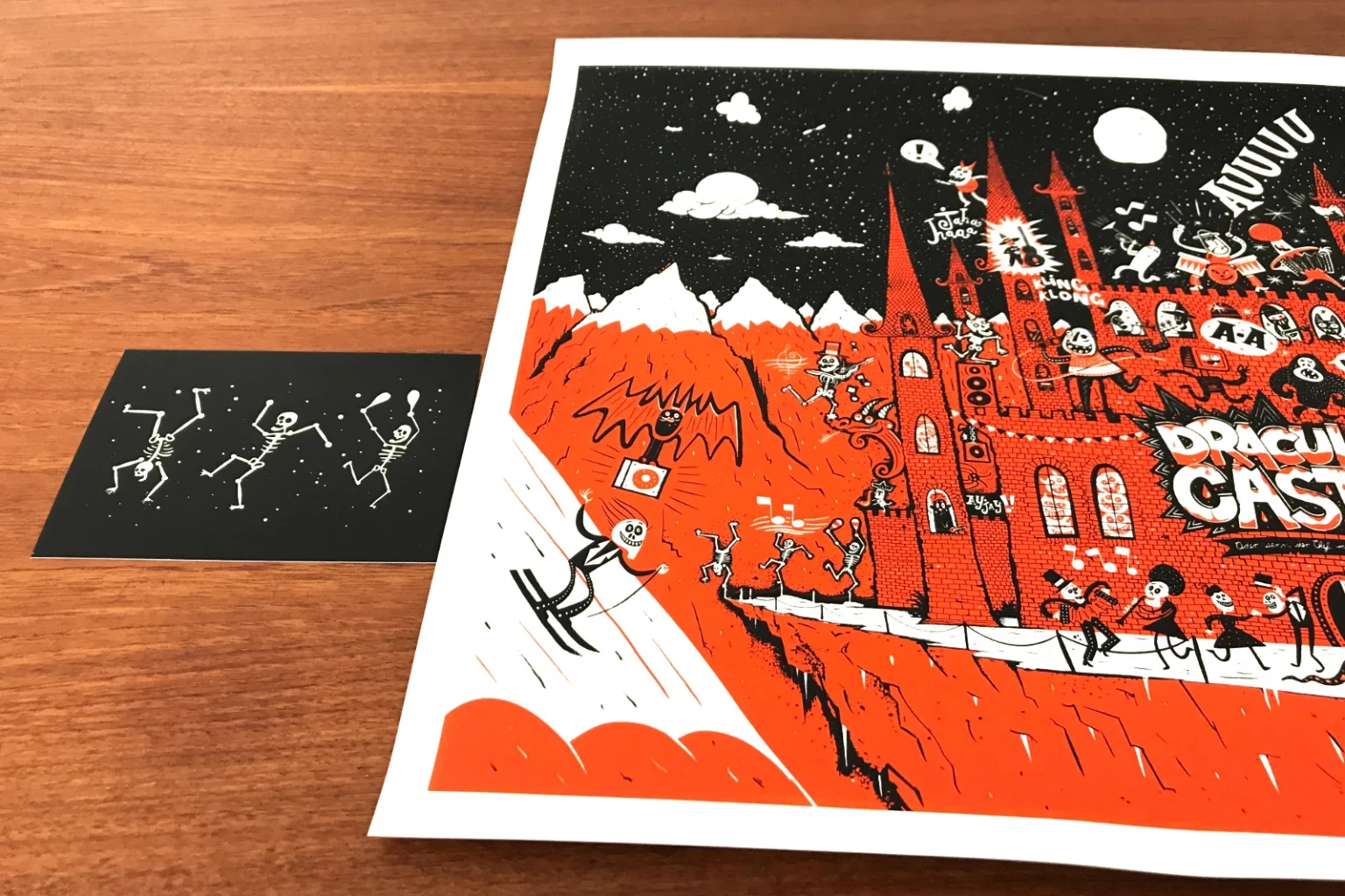 Dracula-Set mit Postkarte und Siebdruckposter nebeneinander auf Tisch liegend