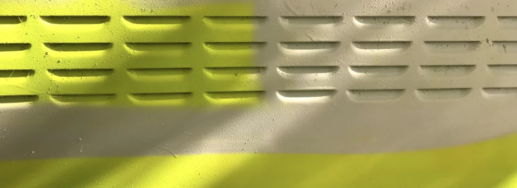 Erste gelbe Farbschicht auf dem Stromkasten während des Malprozesses