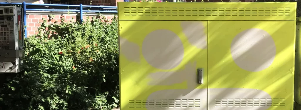 Gelbe Grundfarbe bedeckt den Stromkasten im Straßenraum